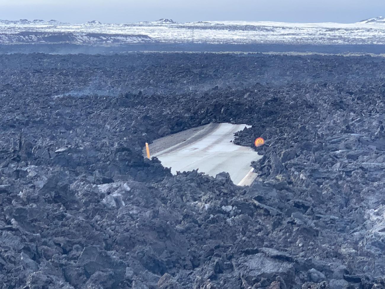 Hér sést í veginn undir hrauninu.