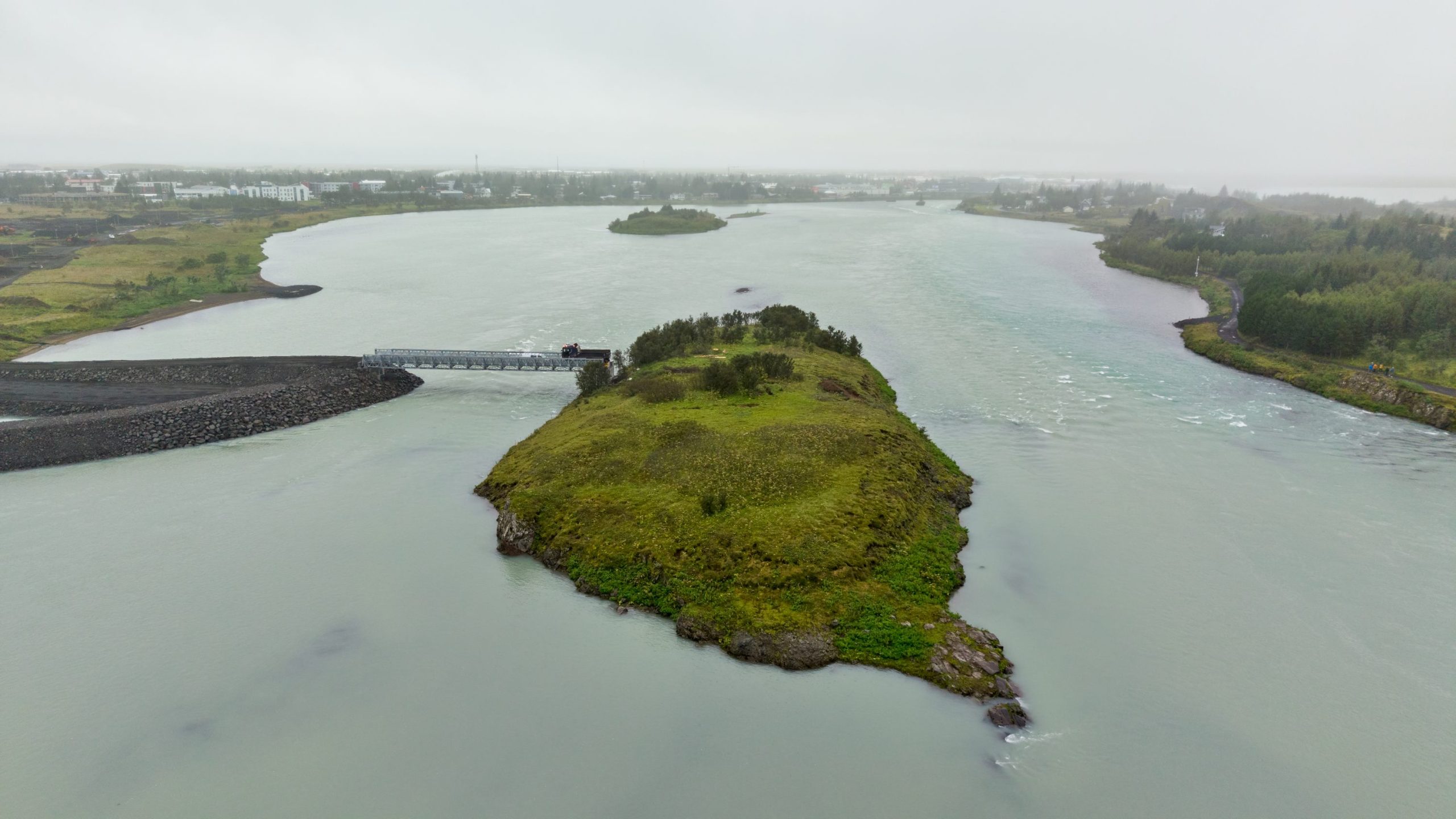 Varnargarður og vinnuvegur hefur verið gerður frá austurbakka árinnar að bráðabirgðabrúnni og þessa dagana er unnið við frágang fyllinga að brúnni úti í eyjunni. 